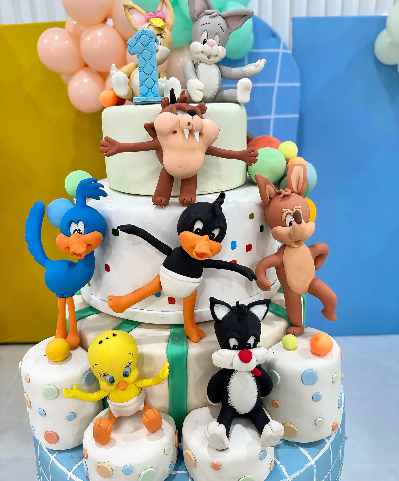 Bolo de vários andares com os personagens da festa.