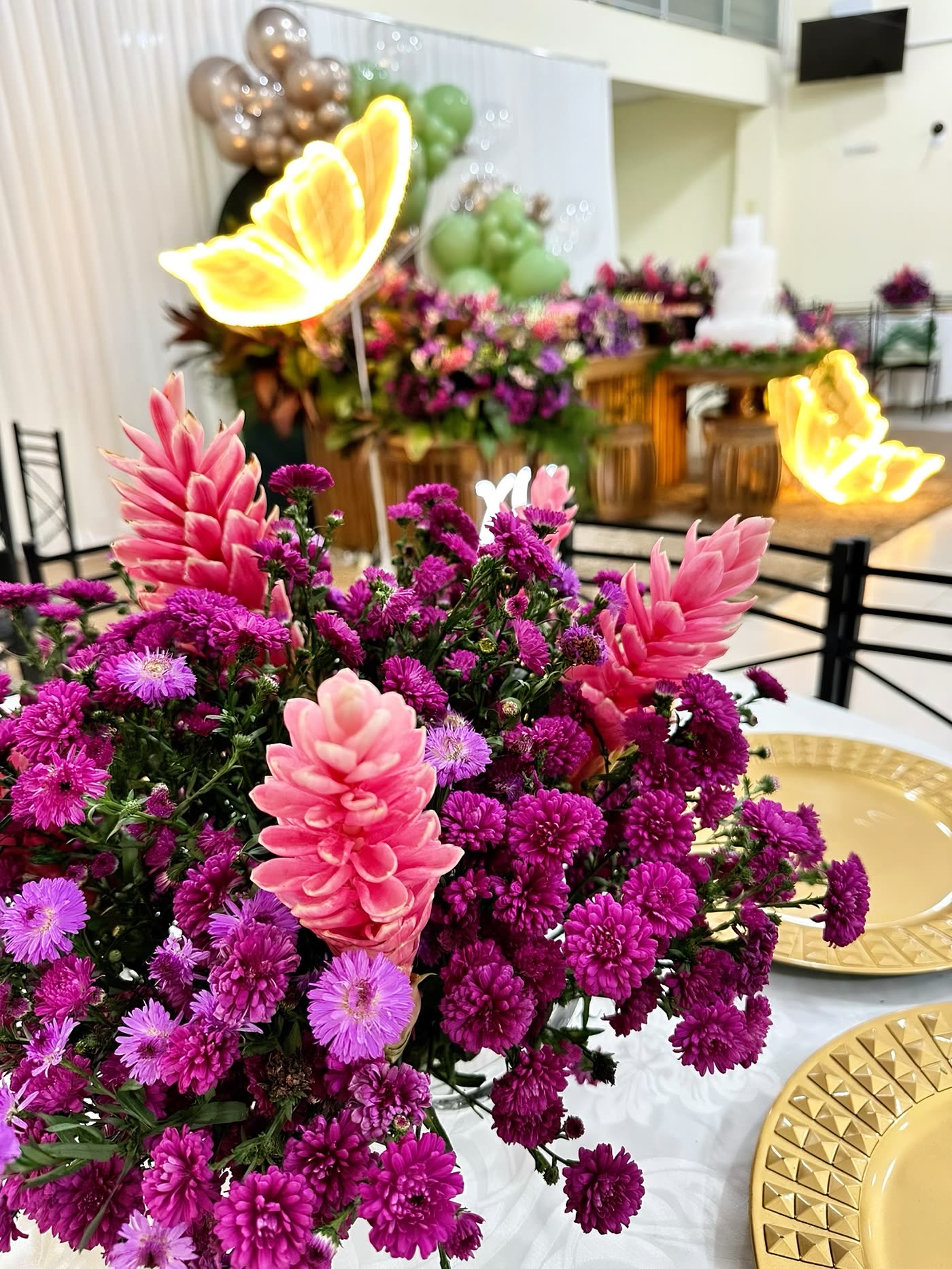Arranjo de flores rosa e roxas na mesa de bolo.