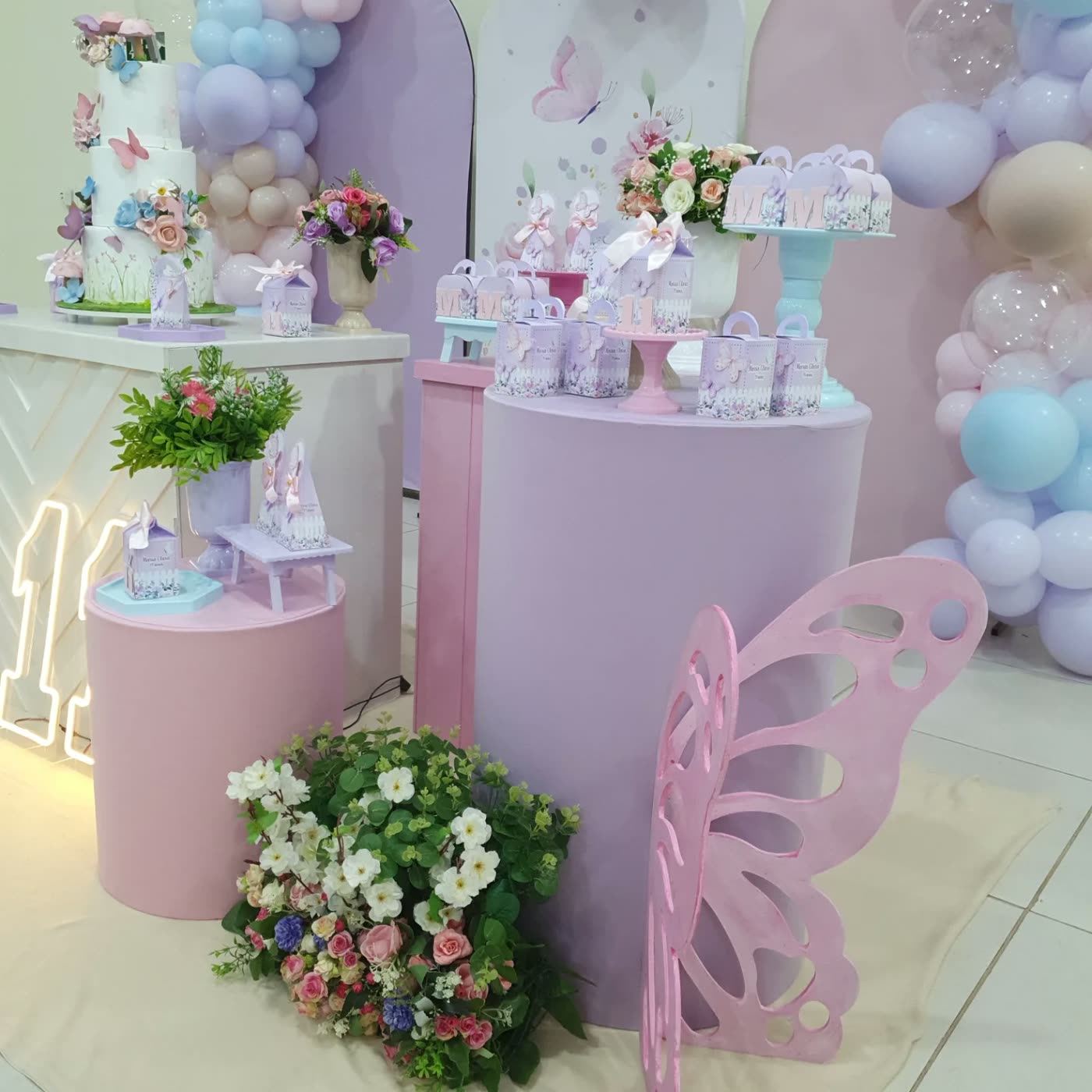 Decoração em rosa e lilás, com arcos e flores.